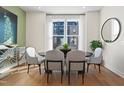 Bright dining room with large windows, round table, and four grey chairs at 1508 Village Hall Ln, Wake Forest, NC 27587