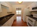 Well-equipped kitchen featuring granite countertops and white cabinets at 108 Long Shadow Pl, Durham, NC 27713