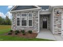 Inviting front entrance with stone facade, dark door, and landscaping at 1680 Abberly Pl, Graham, NC 27253
