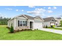 Gray siding, white garage door, and well-manicured lawn at 2508 Trevana Way, Graham, NC 27253