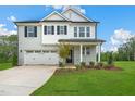 Two-story home with gray brick and white accents, two-car garage, and landscaped yard at 8749 Maxine St # 11 Holly, Willow Springs, NC 27592