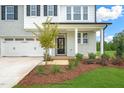Front entrance with a covered porch, gray brick exterior, and landscaping at 8749 Maxine St # 11 Holly, Willow Springs, NC 27592