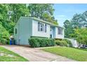 Side view of a light blue house with a driveway and green landscaping at 2216 Lawrence Dr, Raleigh, NC 27603