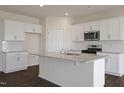 Modern kitchen with white cabinets, granite island, and stainless steel appliances at 409 Blue Aspen Dr, Fuquay Varina, NC 27526