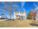 Two-story house with beige siding, a brick chimney, and a landscaped lawn at 502 Lemontree Ct, Graham, NC 27253