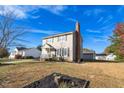 Two-story house with beige siding, a brick chimney, and a landscaped lawn at 502 Lemontree Ct, Graham, NC 27253