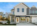 Two-story townhome with gray siding, stone accents, and a covered entryway at 716 Apple Churn Dr, Fuquay Varina, NC 27526