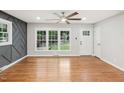 Living room featuring hardwood floors, gray accent wall, and ceiling fan at 2112 Eastwood Dr, Durham, NC 27703