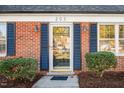 Front entrance with blue shutters, brick facade, and landscaping at 203 Hillside Dr, Smithfield, NC 27577