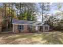 Brick ranch house with a landscaped yard and mature trees at 3316 Alabama Ave, Durham, NC 27705