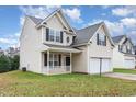 Two-story house with beige siding, a white garage door, and a well-maintained lawn at 2124 Star Sapphire Dr, Raleigh, NC 27610