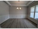 Formal dining room with chandelier, wainscoting, and large windows at 120 Lemon Drop Ln, Franklinton, NC 27525