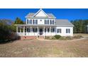 Two-story white house with a gray roof, brick base, and a front porch at 1521 Upchurch Woods Dr, Raleigh, NC 27603