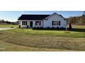 Newly built home with a white exterior, black roof, and grassy yard at 186 Pate Landing Dr, Selma, NC 27576
