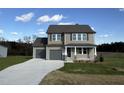 Two-story house with gray siding, gray double garage doors, and a stone accent at 36 Holly Grove Ln, Lillington, NC 27546