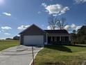 Gray exterior ranch home with attached garage and landscaped lawn at 45 New Bethel Ct, Lillington, NC 27546