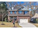 Two-story brick home with gray accents, a two-car garage, and a landscaped lawn at 105 Valleycruise Cir, Garner, NC 27529