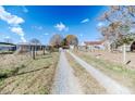 Gravel driveway leading to the property with various outbuildings visible at 4216 New Hill Holleman Rd, New Hill, NC 27562