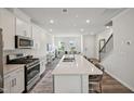 Open concept kitchen with island, stainless steel appliances, and white cabinets at 671 Mirkwood, Apex, NC 27523