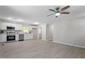 Open living room and kitchen with grey laminate flooring and ceiling fan at 2612 Glenbrook Dr, Durham, NC 27704