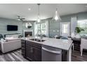 Open concept kitchen with island, stainless steel appliances, and view into living room at 2782 Farmhouse Dr, Apex, NC 27502