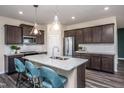 Modern kitchen with dark cabinetry, granite island, and stainless steel appliances at 2782 Farmhouse Dr, Apex, NC 27502