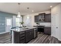 Modern kitchen with dark cabinetry, granite island, and stainless steel appliances at 2782 Farmhouse Dr, Apex, NC 27502