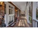 Spacious front porch with a wicker swing and brick flooring at 4027 Green Forest Ct, Rocky Mount, NC 27804