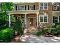 Inviting front porch with stone steps and double doors at 7061 Landingham Dr, Willow Springs, NC 27592