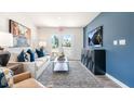 Open living room with comfortable seating, large TV, and access to outdoor space at 8656 Brixton Shay Dr, Raleigh, NC 27616