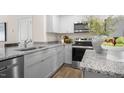 Modern kitchen with granite countertops, stainless steel appliances, and light gray cabinets at 8658 Brixton Shay Dr, Raleigh, NC 27616