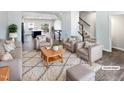 Virtually staged living room with neutral colored furniture and a large area rug at 901 Arnold Place Dr, Fuquay Varina, NC 27526