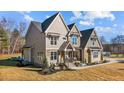 Two-story house with stone and wood accents, a covered porch, and a landscaped yard at 145 Wiggins Rd, Louisburg, NC 27549
