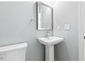 Small bathroom with pedestal sink and white toilet at 408 Cherry St, Fuquay Varina, NC 27526
