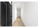 Bright hallway with light wood floors and black door at 408 Cherry St, Fuquay Varina, NC 27526
