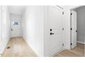 White hallway with light wood floors and doors to rooms at 408 Cherry St, Fuquay Varina, NC 27526