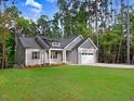 Gray house with white trim, two-car garage, and a green lawn at 652 Shawnee Dr, Louisburg, NC 27549