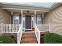 Inviting front porch with brick steps and white railing at 7217 Blannie Farms Ln, Willow Springs, NC 27592