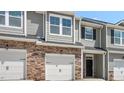 Gray townhome exterior with stone accents, two-car garage, and landscaping at 1827 Hinesley Dr, Durham, NC 27703