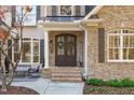 Inviting front entrance with double doors, brick columns, and a welcoming wreath at 209 Morayshire Ct, Holly Springs, NC 27540