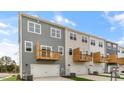 Rear view of townhomes showcasing private balconies and attached garages at 2243 Horton Park Drive, Apex, NC 27539