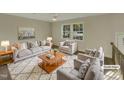 Virtually staged living room with light gray sofa and armchairs at 302 N Montreal Ct, Cary, NC 27511