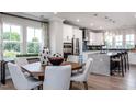 Modern eat-in kitchen with island, stainless steel appliances, and white cabinets at 1212 Holding Village Way, Wake Forest, NC 27587