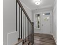 Bright entryway with hardwood floors and staircase with black metal railing at 507 Excelsior Ct, Rolesville, NC 27587