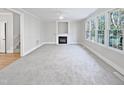 Spacious living room with a fireplace and large windows at 4700 Linaria Ln, Fuquay Varina, NC 27526