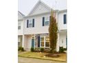 Two-story townhome with gray siding, teal door, and stone accents at 242 Liam St, Clayton, NC 27520