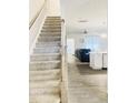 Carpeted staircase with light wood railing leading to the living area at 242 Liam St, Clayton, NC 27520