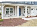 Covered front porch with stone accents and a blue front door at 68 Northwood Dr, Fuquay Varina, NC 27526