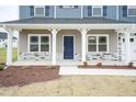 Covered front porch with stone accents and a blue front door at 68 Northwood Dr, Fuquay Varina, NC 27526