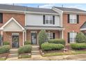 Brick front of charming townhome with landscaping and steps leading to the entrance at 9009 Grassington Way, Raleigh, NC 27615